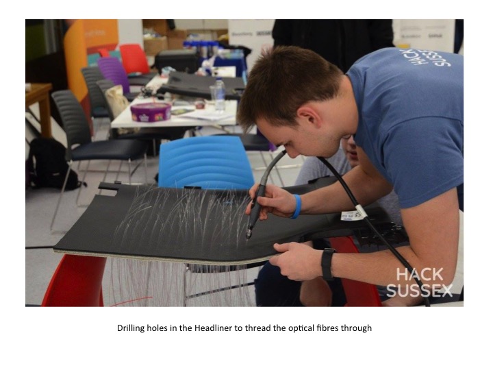 Me threading optic fibers into a piece of roof liner